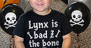 Lynx joined the competition — help win amazing prizes! child, boy, smiling, portrait, birthday, party, balloons, skull, bones, lightning, black_shirt, play_mat, indoors, carpet, kneeling, blond_hair, happy, costume, celebration, photography