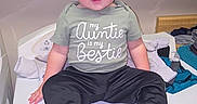Waylan joined the competition — help win amazing prizes! child, toddler, sitting, portrait, indoors, changing_table, clothing, shirt, pants, shoes, smiling, blonde_hair, face, person, baby, furniture, laundry, home, photography, casual