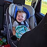 baby, child, car, car_seat, smiling, happy, sitting, infant, blanket, toy, vehicle, indoors, road_trip, sunlight, countryside, window, seatbelt, portrait, family, travel