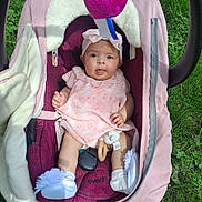 Sophia joined the competition — help win amazing prizes! baby, infant, child, pink_dress, headband, baby_carrier, blanket, grass, outdoor, toy, white_shoes, cute, playful, tongue_out, soft_toys, sunlight, person, seat, comfort, smile