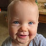 baby, blue_eyes, smiling, close_up, face, infant, child, portrait, indoor, cozy, cute, happy, skin, young_child, apparel, head, person, human, expression, blond_hair