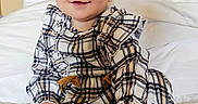 Skyler is registered to the contest to win money with this photo: baby, child, smile, blue_eyes, plaid, dress, headband, bow, sitting, bed, blanket, indoor, cute, fashion, portrait, young_child, happy, soft_lighting, cozy, infant
