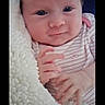 adorable, awake, baby, blanket, child, close_up, cozy, cute, eyes, face, hands, indoor, infant, lying_down, photography, pink_clothing, portrait, smiling, soft_blanket, striped_clothing