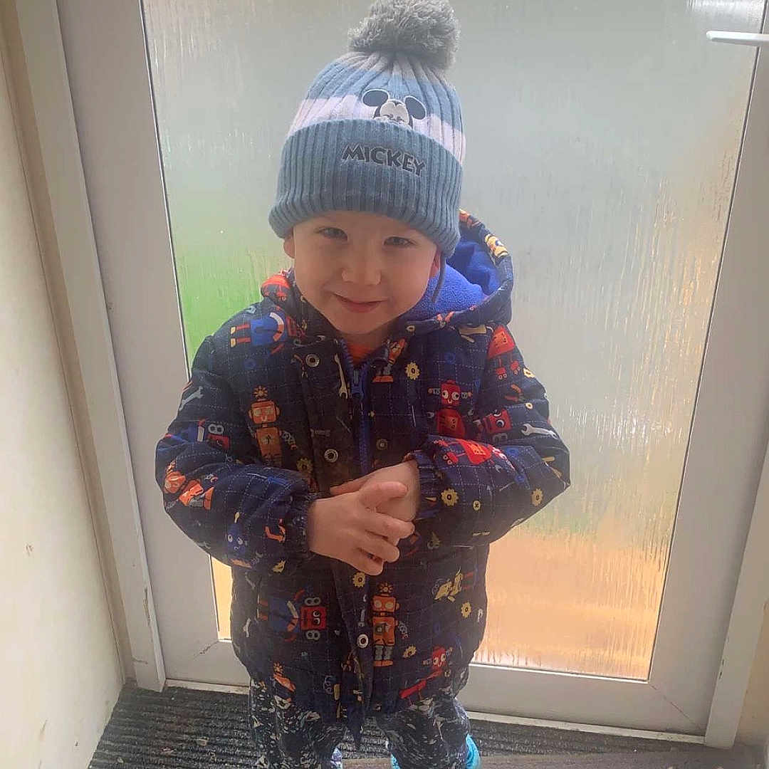 Noah joined the competition — help win amazing prizes! boy, cap, child, clothing, coat, door, face, footwear, hat, head, indoors, jacket, jeans, male, pants, person, photography, portrait, shoe, sitting