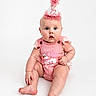 baby, infant, child, portrait, birthday, party_hat, pink, outfit, sitting, wide_eyed, surprised, smiling, face, blue_eyes, studio, white_background, photography, celebration, lace, adorable