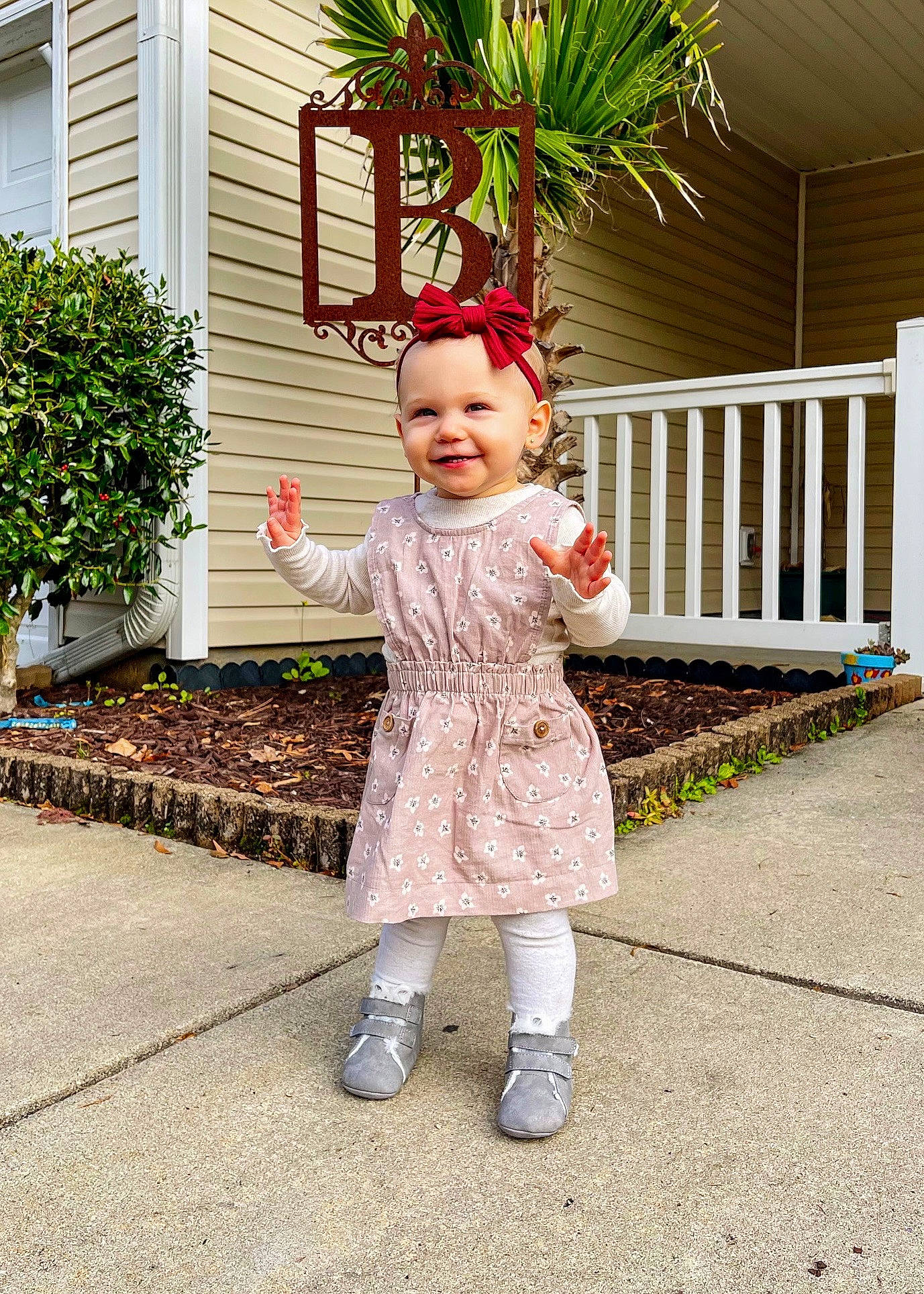 Ansley is registered to the contest to win money with this photo: baby_toddler_clothing, building, child, fun, garden, grass, happy, headwear, house, human_leg, joy, leaf, magenta, pattern, people_in_nature, person, pink, plant, sleeve, smile