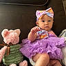 Ivyanna joined the competition — help win amazing prizes! baby, child, tutu, purple, bow, headband, plush_toy, teddy_bear, couch, furniture, indoor, cute, infant, sitting, clothing, foot, face, expression, living_room, soft_toy
