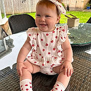 Amelie joined the competition — help win amazing prizes! toddler, child, smiling, outdoor, table, glass_table, headband, clothing, socks, strawberry_pattern, grass, fence, garden, chair, happy, baby, person, summer, cute, portrait