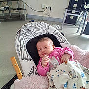 Nour participe au concours pour gagner de l'argent avec cette photo : baby, infant, blanket, pink_clothing, baby_chair, face, indoor, living_room, television, remote_control, furniture, cushion, person, child, cute, cozy, resting, expression, floor, home