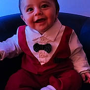 Tiago participe au concours pour gagner de l'argent avec cette photo : baby, bow_tie, chair, child, closeup, clothing, cute, face, fashion, happy, indoor, infant, person, portrait, red_outfit, seated, smiling, socks, white_shirt, young