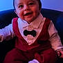 baby, bow_tie, chair, child, closeup, clothing, cute, face, fashion, happy, indoor, infant, person, portrait, red_outfit, seated, smiling, socks, white_shirt, young
