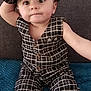 baby, blue_blanket, buttoned_vest, casual, child, clothing, curious_expression, cute, face, gray_couch, hat, headwear, indoor, pants, person, plaid_outfit, portrait, sitting, toddler, young_child