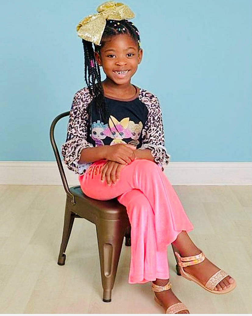 Kynslei is registered to the contest to win money with this photo: embellishment, face, fashion_design, happy, head, headpiece, human_leg, jewellery, joy, knee, long_hair, magenta, neck, pattern, person, pink, sandal, shoe, sleeve, smile