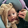 baby, child, car_seat, fluffy_clothing, bear_costume, hand, smile, happy, cute, infant, person, portrait, seat_belt, car_interior, warm_clothing, young_child, face, expressive_eyes, cozy, comfort
