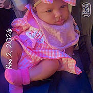 Olivia joined the competition — help win amazing prizes! baby, infant, pink_clothing, bow_headband, car_seat, cute, child, soft_lighting, portrait, sitting, indoors, clothing, footwear, accessory, smiling, young_child, headwear, seatbelt, closeup, adorable