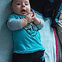 baby, child, infant, blue_shirt, pants, lying_down, towel, indoor, smiling, hands, cute, person, young_child, clothing, happy, face, skin, socks, casual, expression