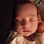 baby, sleeping, infant, onesie, teddy_bear_pattern, face, peaceful, child, cute, closeup, soft_lighting, resting, newborn, portrait, skin, hand, cozy, indoors, calm, adorable