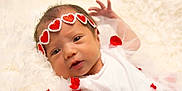 Rubyrae is registered to the contest to win money with this photo: baby, newborn, infant, headband, red_hearts, white_clothing, blanket, soft_texture, cute, portrait, lying_down, small_hands, face, eyes_open, tulle, fabric, adorable, child, closeup, gentle