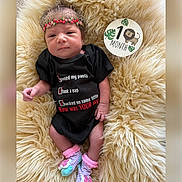 Rubyrae joined the competition — help win amazing prizes! baby, infant, onesie, crown, floral, socks, milestone, lion, plush, rug, cute, newborn, lying_down, portrait, child, soft_texture, funny_text, black_clothing, pink, purple