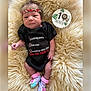 baby, infant, onesie, crown, floral, socks, milestone, lion, plush, rug, cute, newborn, lying_down, portrait, child, soft_texture, funny_text, black_clothing, pink, purple