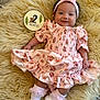 baby, infant, girl, pink_dress, headband, smile, lying_down, fluffy_rug, milestone_sign, 2_months, white_booties, socks, flower_pattern, cute, portrait, child, indoors, soft_texture, happy, small