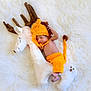 baby, infant, costume, knitted, lion, plush, reindeer, stuffed_animal, sleeping, cute, soft, white_background, orange_clothing, newborn, child, cozy, resting, toy, fluffy, indoor