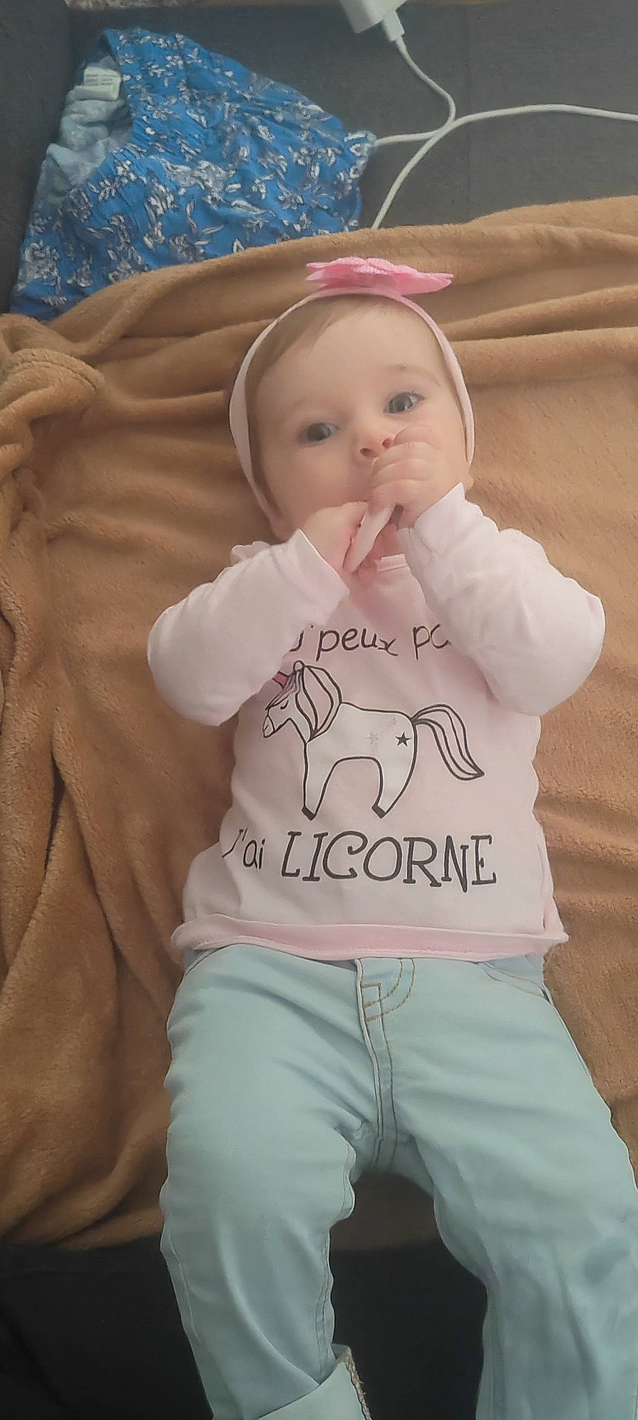 Myla participe au concours pour gagner de l'argent avec cette photo : baby, baby_products, baby_toddler_clothing, cheek, child, comfort, eyebrow, face, gesture, happy, linens, nose, person, pink, sitting, skin, sleeve, smile, t_shirt, textile