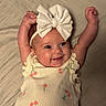 baby, infant, smile, happy, cute, headband, bow, cherry_pattern, diaper, sleeveless_top, lying_down, bed, blanket, skin, arms_up, cheeks, portrait, child, clothing, indoor