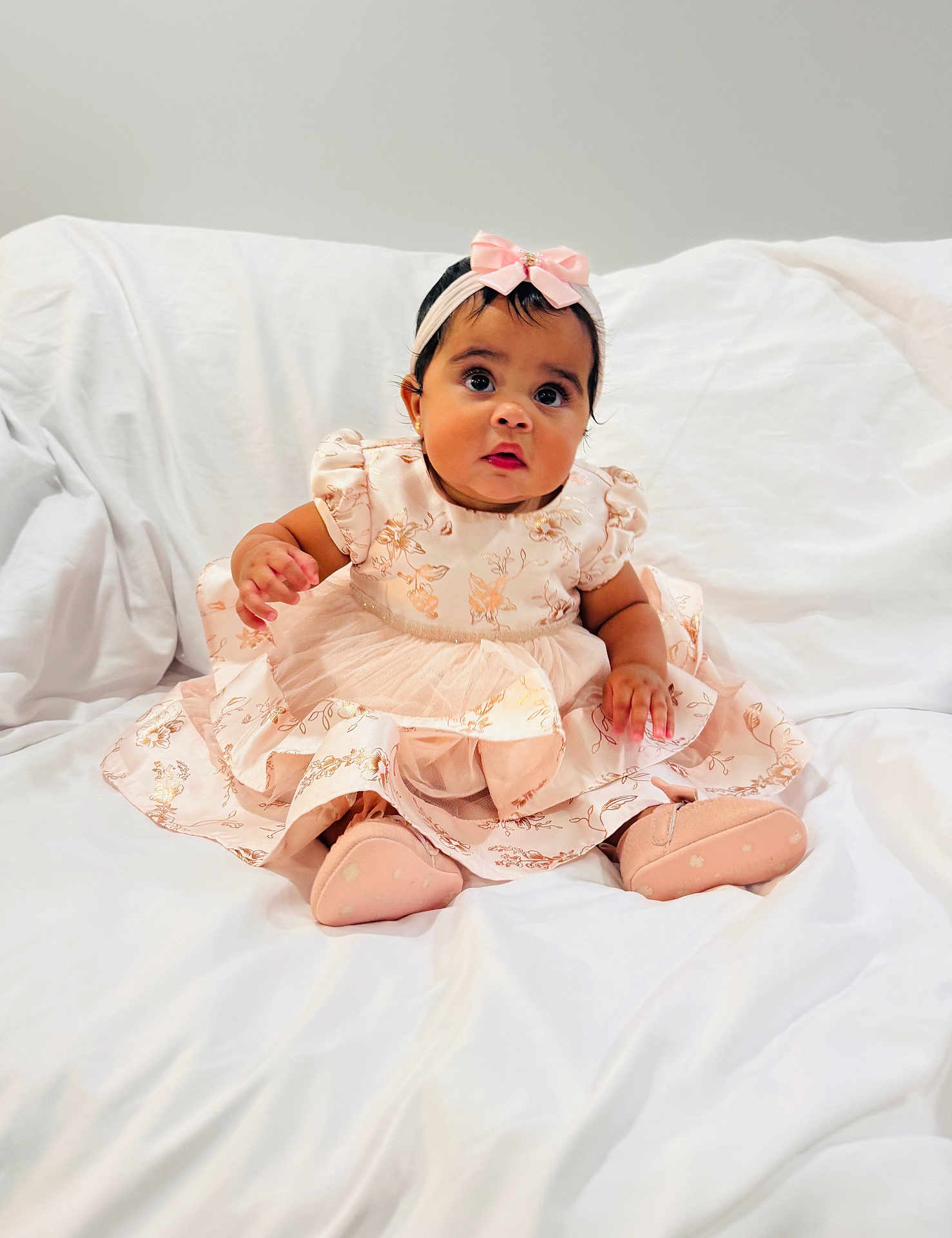 Ariella is registered to the contest to win money with this photo: baby, child, girl, dress, headband, pink, sitting, indoors, blanket, cute, portrait, infant, footwear, soft, young, person, fashion, happy, smiling, studio