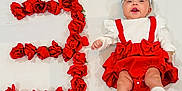 Ariella joined the competition — help win amazing prizes! baby, child, red_dress, white_headband, roses, number_two, milestone, celebration, smiling, lying_down, cute, festive, white_background, socks, puffy_sleeves, portrait, happy, flower_arrangement, infant, clothing