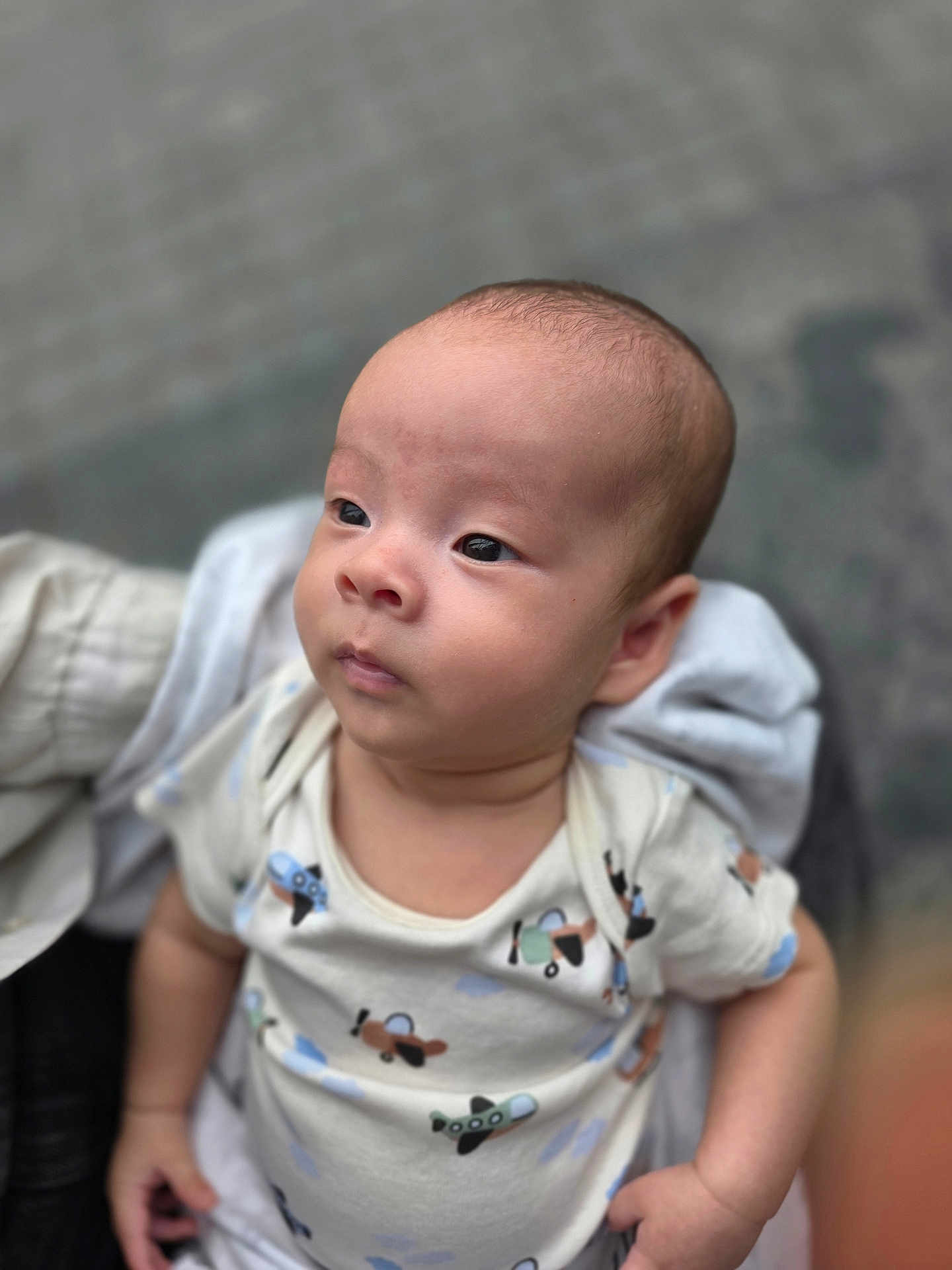Aodhan is registered to the contest to win money with this photo: baby, infant, child, person, clothing, onesie, pattern, airplane, cute, portrait, face, head, expression, hand, skin, outdoor, blurred_background, holding, young, casual