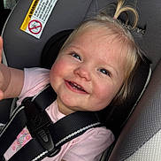 Layla joined the competition — help win amazing prizes! baby, child, car_seat, smile, happy, blonde_hair, pony_tail, safety_harness, pink_shirt, infant, seat_belt, cute, face, blue_eyes, cheeks, young_child, portrait, indoor, close_up, person