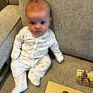 Sabrina is registered to the contest to win money with this photo: baby, child, onesie, couch, fabric, portrait, indoor, person, face, sitting, photograph, vintage_photo, nostalgia, expression, cute, infant, home, cozy, texture, seated