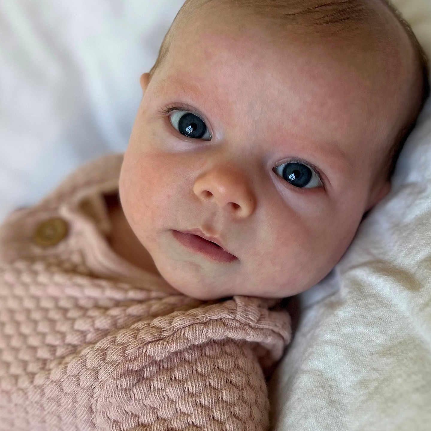 Sabrina is registered to the contest to win money with this photo: baby, child, close_up, cute, expression, eyes, face, infant, innocent, knitwear, lying_down, newborn, pink_clothing, portrait, skin, soft, texture, warm, white_background, young_child