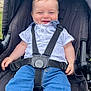 Mylo participe au concours pour gagner de l'argent avec cette photo : baby, child, stroller, smiling, harness, clothing, white_shirt, blue_jeans, outdoor, grass, seat, happy, person, portrait, cute, infant, casual, sitting, daylight, young