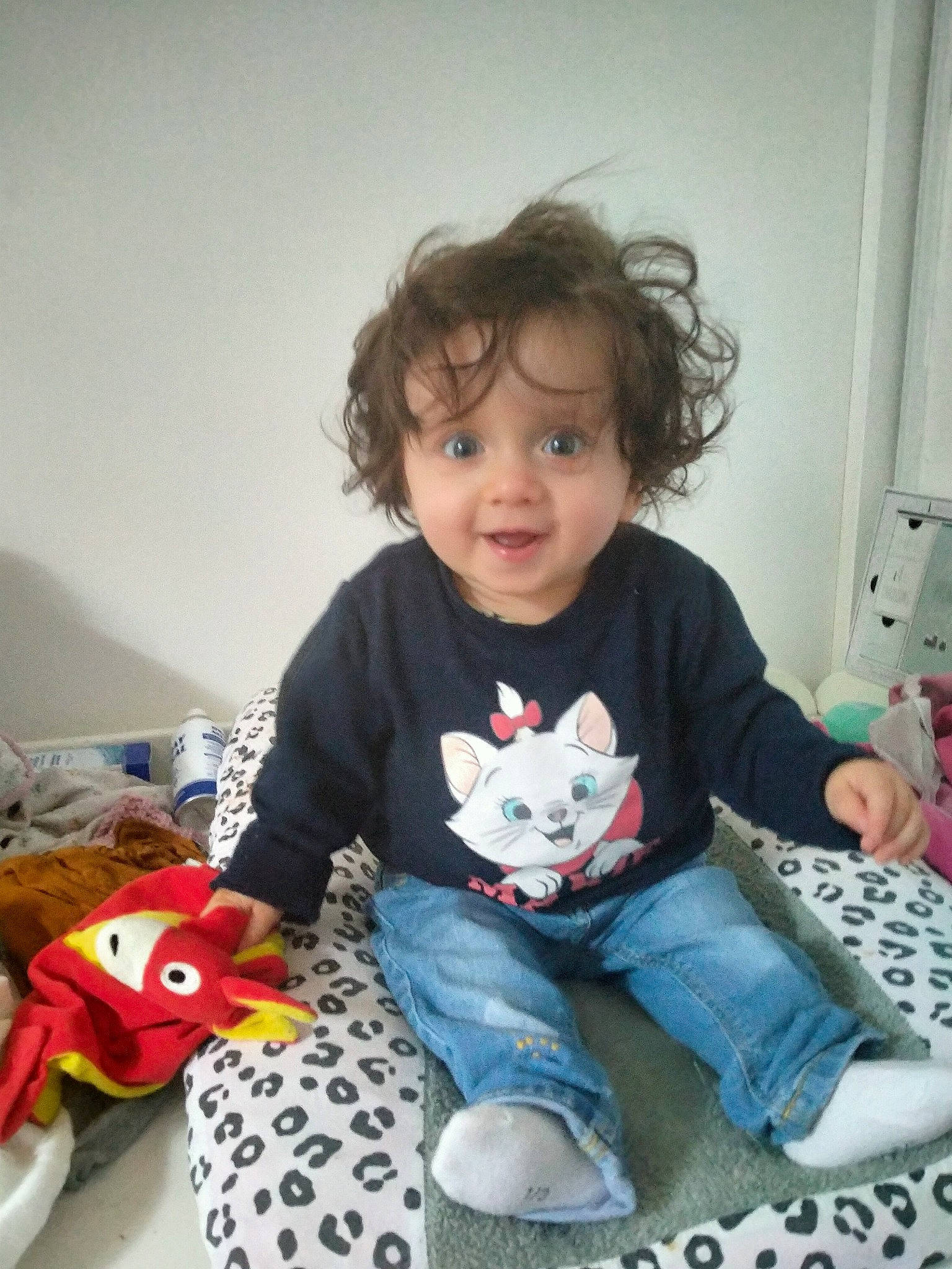 Léana participe au concours pour gagner de l'argent avec cette photo : baby_playing_with_toys, baby_toddler_clothing, carmine, child, face, fun, happy, head, holiday, jeans, pattern, person, play, sitting, sleeve, smile, sock, t_shirt, textile, toddler