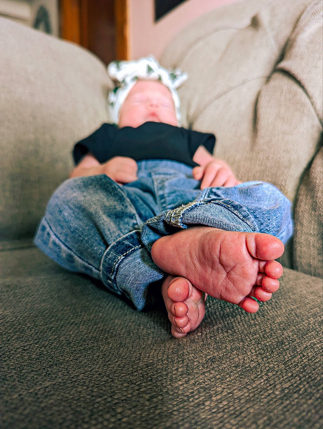 Darcy is registered to the contest to win money with this photo: baby, barefoot, comfort, couch, denim, finger, flooring, foot, gesture, grass, human_leg, jeans, joint, knee, lap, leg, person, sitting, thigh, toddler
