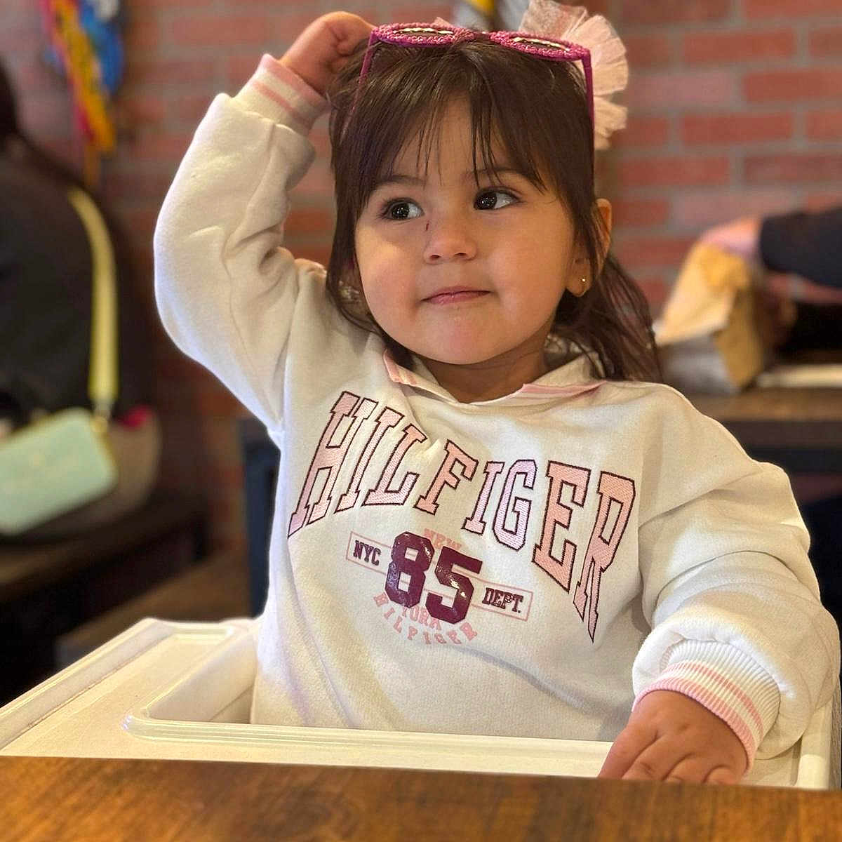 Gabriella is registered to the contest to win money with this photo: child, clothing, drawer, face, female, furniture, girl, happy, hardwood, head, indoors, person, photography, plywood, portrait, sleeve, smile, t_shirt, table, wood