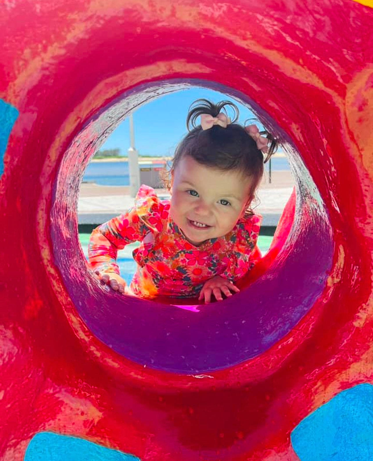 Hallie is registered to the contest to win money with this photo: automotive_wheel_system, baby_toddler_clothing, child, circle, city, electric_blue, eye, fun, happy, joy, leisure, magenta, outdoor_play_equipment, person, pink, playground, recreation, red, sleeve, smile