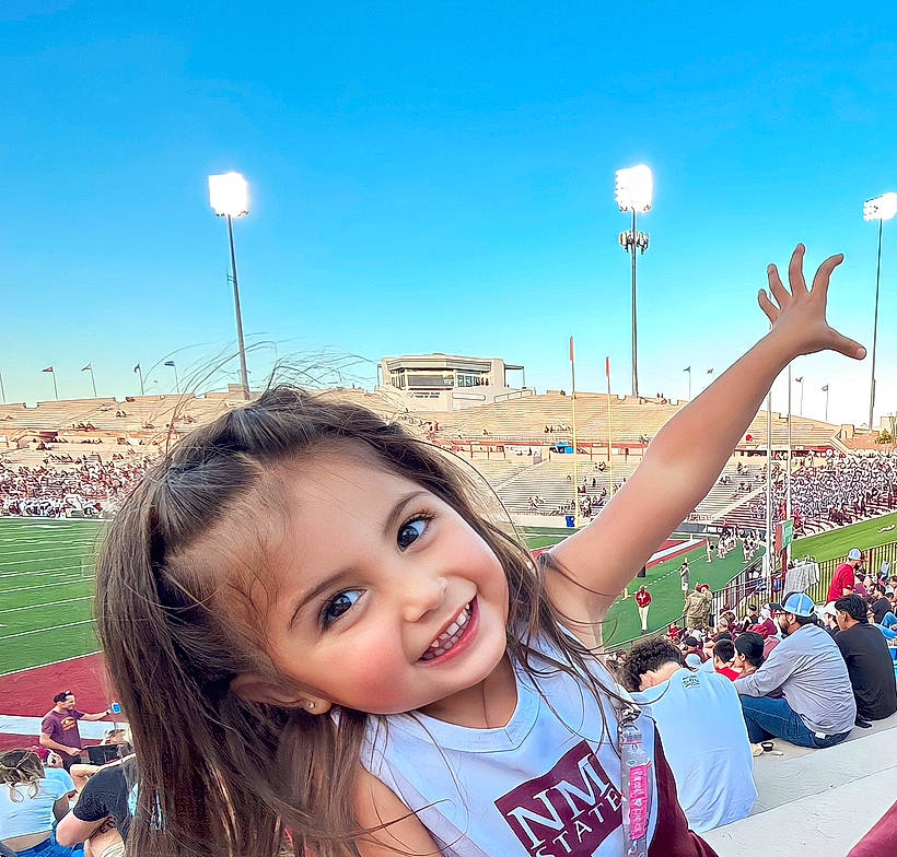 Maya is registered to the contest to win money with this photo: cool, event, facial_expression, fan, fun, gesture, grass, hair, happy, joy, leisure, ocean, person, recreation, sky, smile, stadium, street_light, t_shirt, tourism