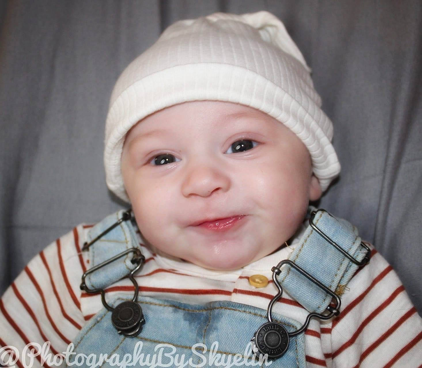 Mason is registered to the contest to win money with this photo: baby, baby_toddler_clothing, cap, cheek, collar, electric_blue, eye, eyebrow, eyelash, face, happy, headwear, iris, lip, nose, person, product, skin, sleeve, smile
