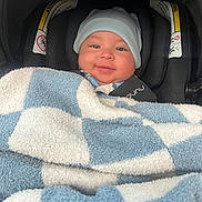 Adriel joined the competition — help win amazing prizes! baby, smiling, blanket, blue, white, hat, car_seat, child, infant, cozy, cute, face, person, seatbelt, indoors, headwear, warm, toddler, comfort, portrait