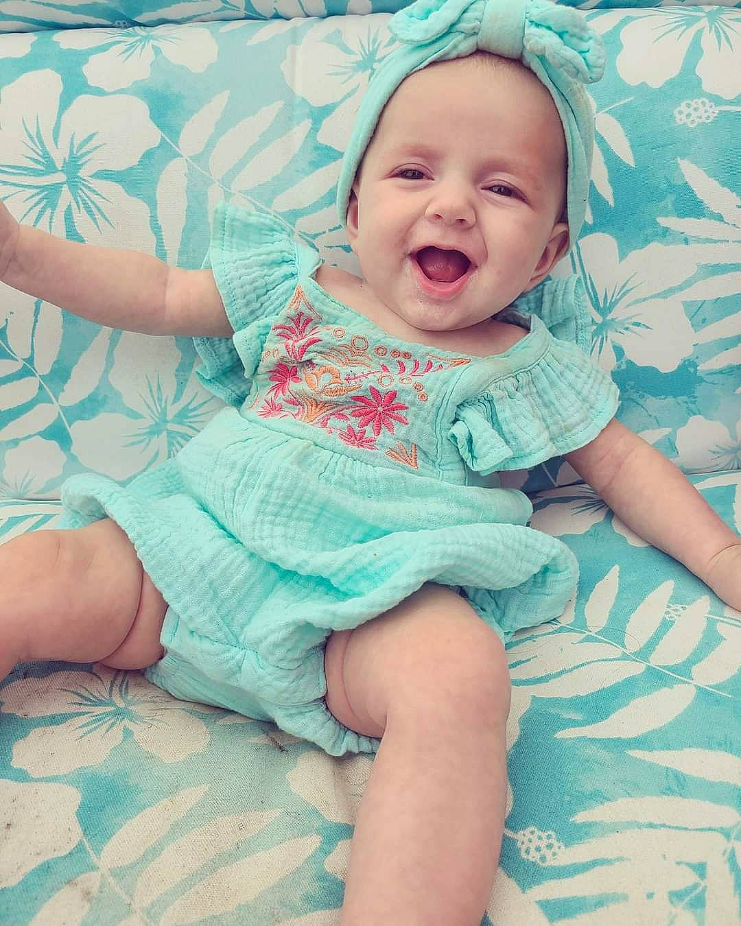 Carlie is registered to the contest to win money with this photo: ankle, aqua, baby, baby_laughing, baby_toddler_clothing, barefoot, comfort, foot, linens, mouth, nightwear, person, skin, sock, teal, toddler, toe, tongue, tooth, turquoise