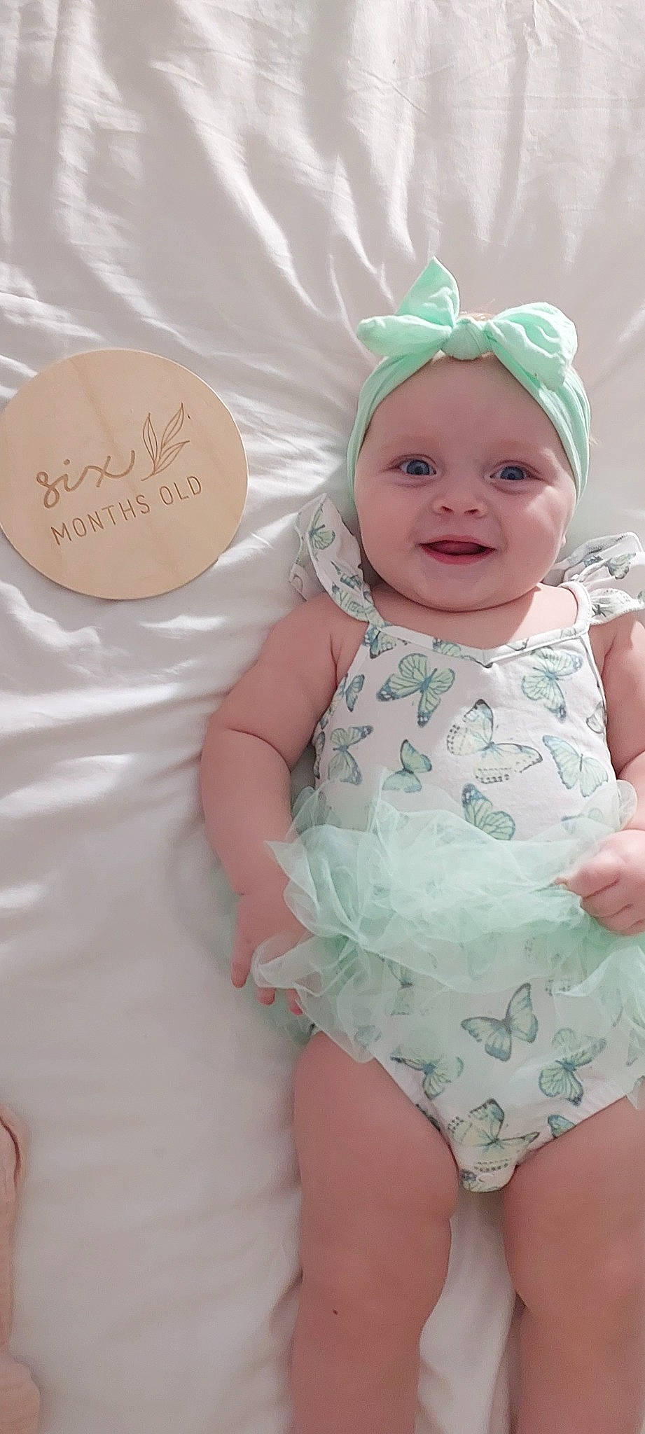 Elle is registered to the contest to win money with this photo: baby, baby_toddler_clothing, cap, child, event, eye, facial_expression, fashion_accessory, hairstyle, handwriting, happy, headband, headpiece, headwear, joy, party_supply, pattern, person, pink, skin