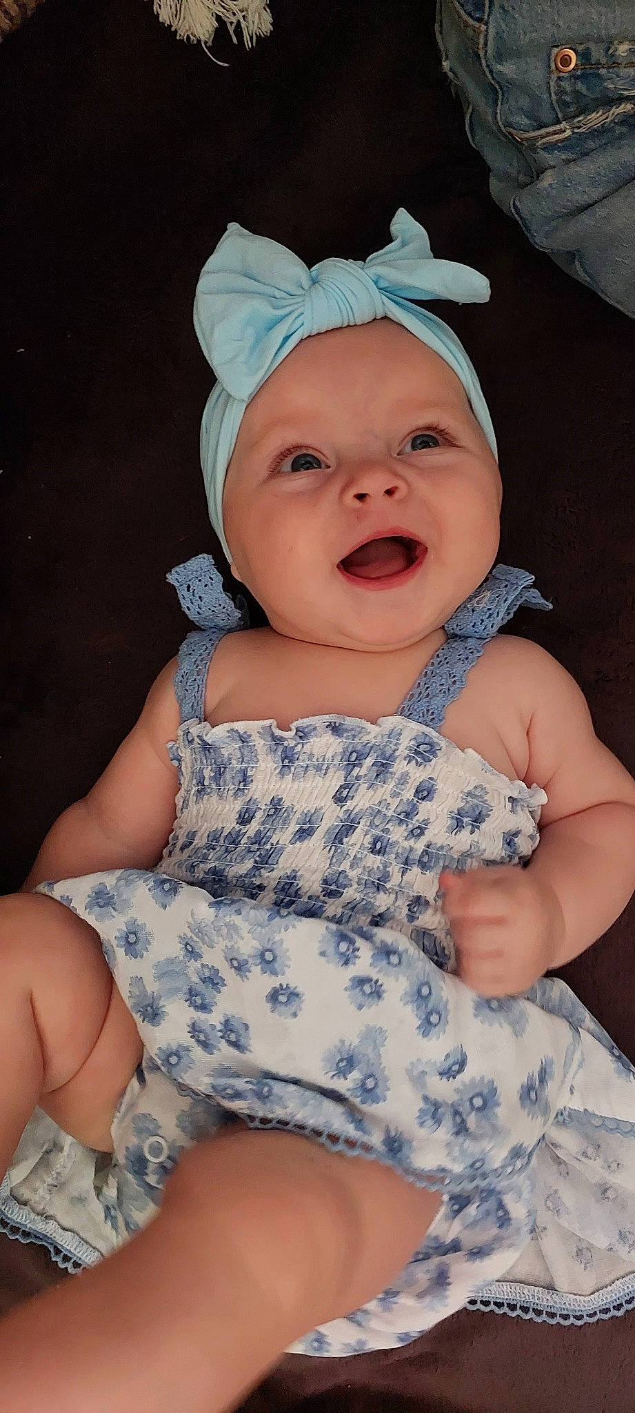 Elle is registered to the contest to win money with this photo: baby, baby_toddler_clothing, cap, child, comfort, face, fashion_accessory, finger, happy, head, headwear, pattern, person, pink, purple, sitting, skin, sleeve, smile, thigh