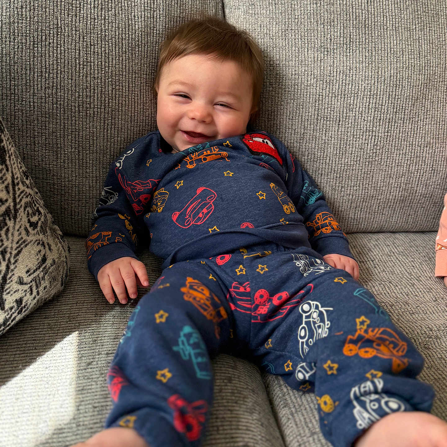 Waylon is registered to the contest to win money with this photo: architecture, baby, bodypart, clothing, couch, cushion, face, finger, furniture, hand, happy, head, homedecor, laughing, pajamas, pants, person, photography, portrait, smile