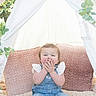 Macie joined the competition — help win amazing prizes! baby, child, tent, blanket, cushion, flowers, plants, indoor, cute, smiling, happy, denim_overalls, white_socks, soft_texture, natural_light, portrait, seated, playful, young_child, decorative