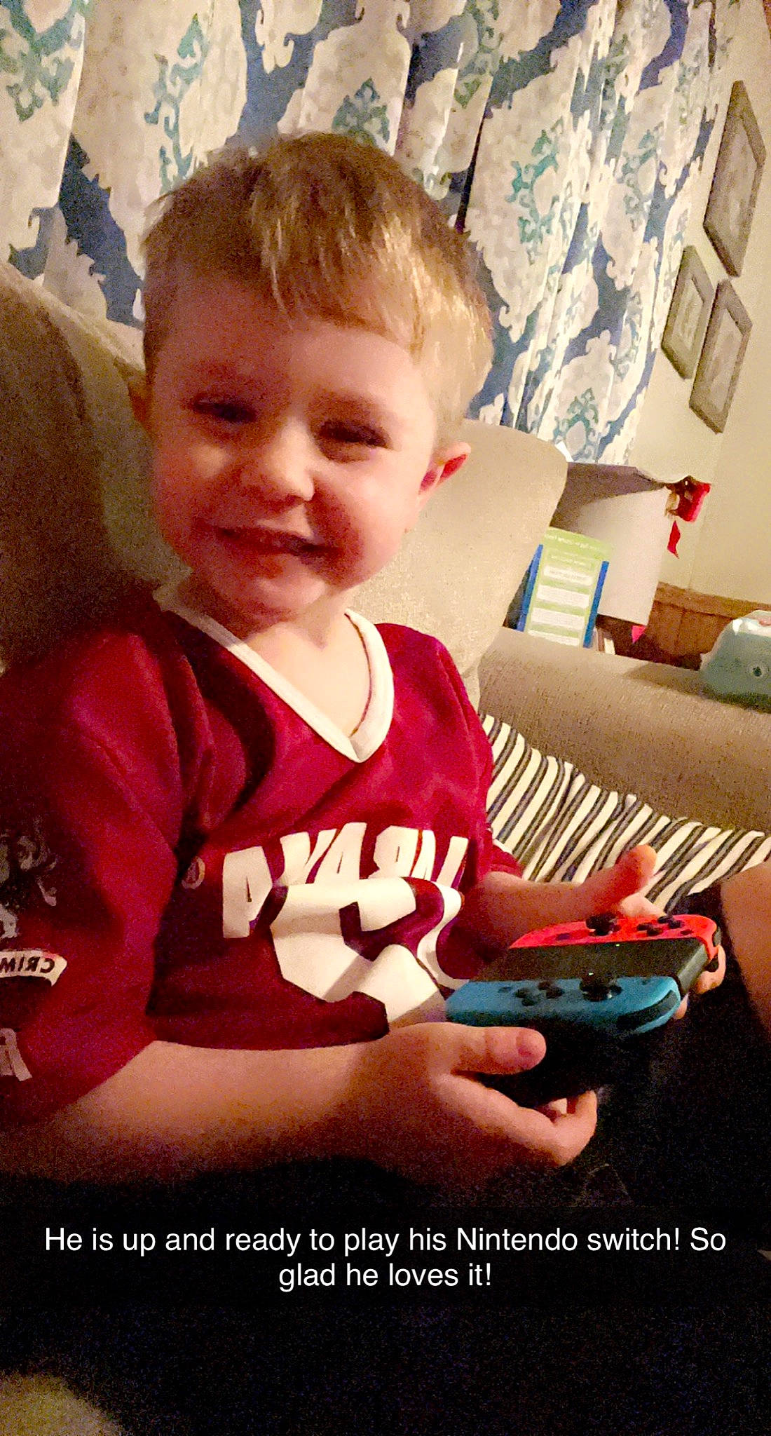 Carter is registered to the contest to win money with this photo: arm, baby, baby_toddler_clothing, carmine, child, finger, fun, gadget, happy, iris, joy, lap, mouth, nail, person, room, sitting, sleeve, smile, t_shirt