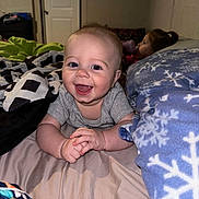 Dawson joined the competition — help win amazing prizes! baby, child, smiling, bed, blanket, indoor, happy, person, face, clothing, sitting, bottle, pajamas, room, sleeping, young_child, portrait, candid, family, cozy
