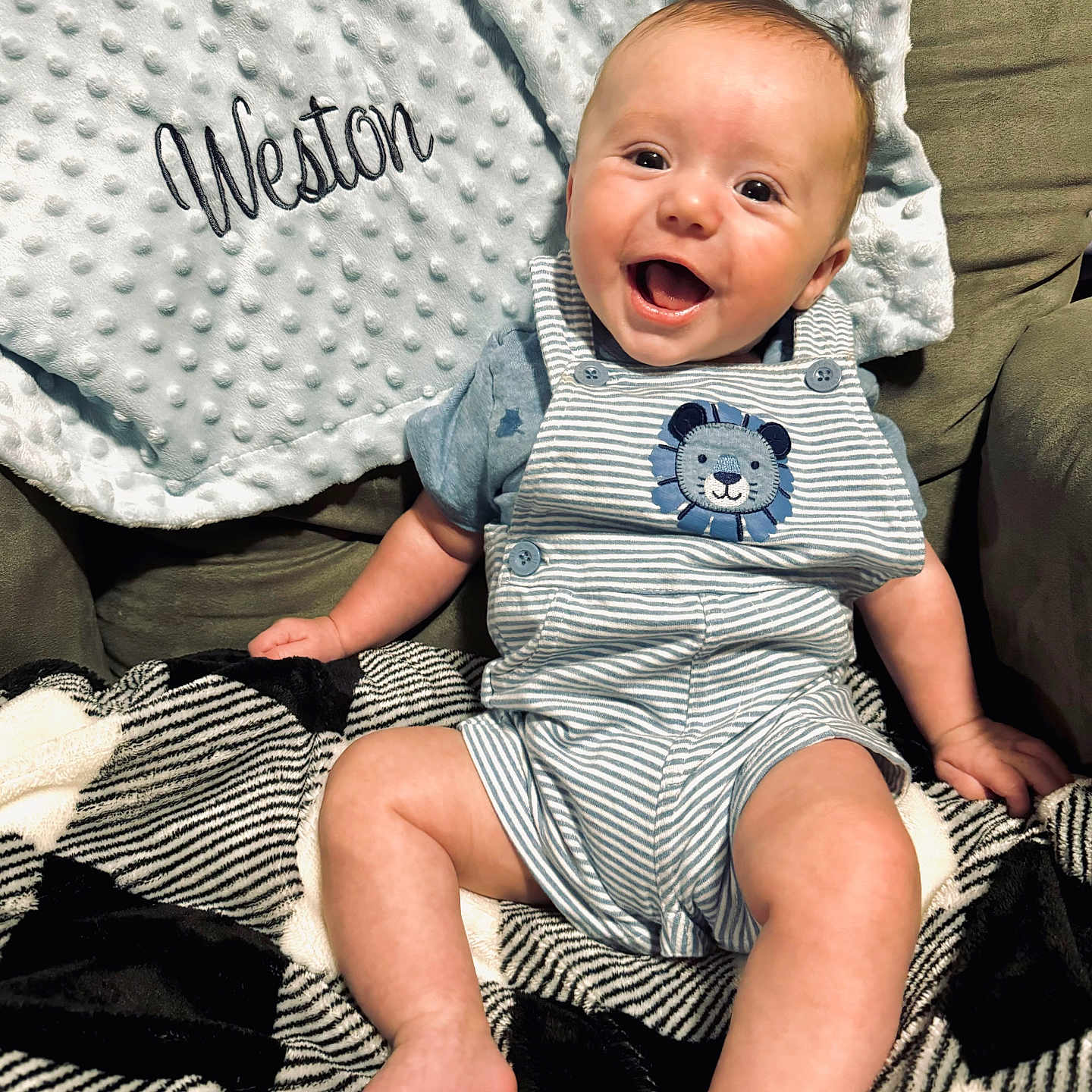 Weston is registered to the contest to win money with this photo: baby, babylaughing, bed, bedroom, clothing, cushion, face, furniture, happy, head, homedecor, indoors, laughing, pants, person, photography, portrait, quilt, sitting, t_shirt